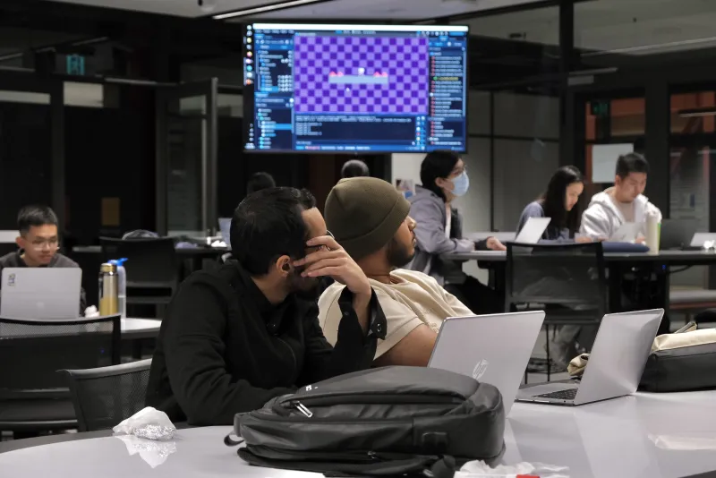 Students collaborating on laptops at a WIRED workshop
